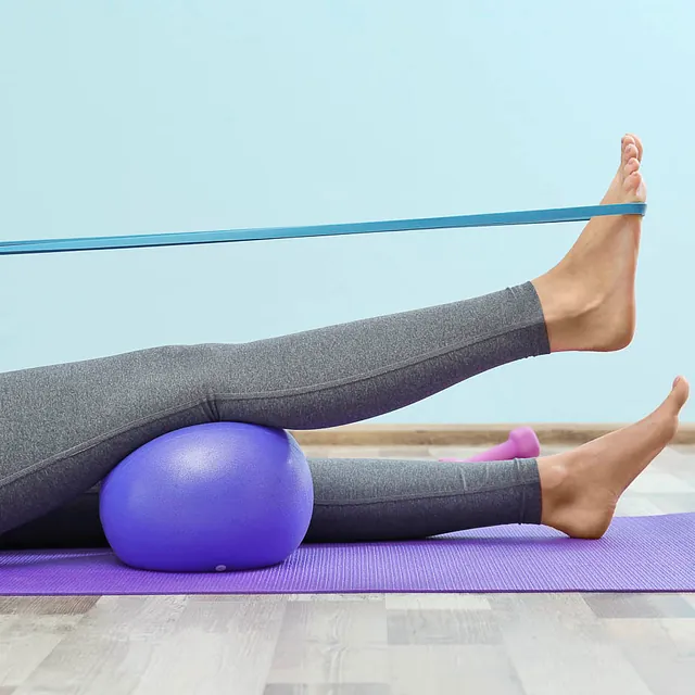 Physiotherapie mit Gymnastikball und Gummiband